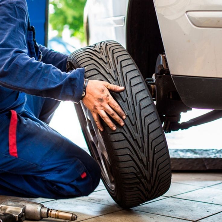 Technician handling a tire during a mobile tire change