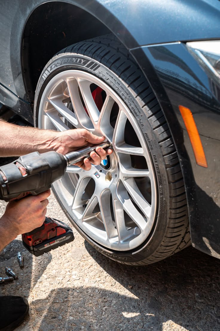 Technician tightening wheel nuts with an impact wrench